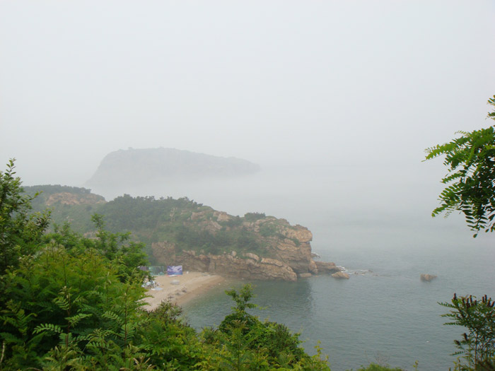 第四天吃完自助早餐,从友好广场打车到棒槌岛风景区,其实就是个有士兵站岗的国宾馆,门票20元太贵感觉像在抢钱。国宾馆里的草地很漂亮,走到里头海在雾霭中、在晴空下,帆影如水墨画,定格在视线的尽头。看不出船从哪里驶向何方;也不知道我目光中星点的帆船离我到底有多远。也许海的博大,在于它能包容更多的沙砾,暗礁总是沉在深不可见的海底,却悠然承载着船儿们的来来往往,不知道那帆船里是否有一双渴盼的目光在注视着海的岸,视野里的海苍茫而辽阔。。。 出来沿着滨海路逛逛走到石槽村的决定严重地成了我们的恶梦,在网上看到也听司机说滨
